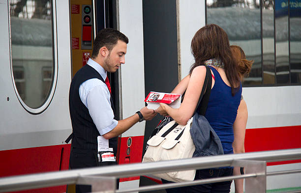 Cologne, Germany - August 30, 2013: Train conductor checks the tickets of female travelers on an international train in the railway station of Cologne, Germany on August 30, 2013